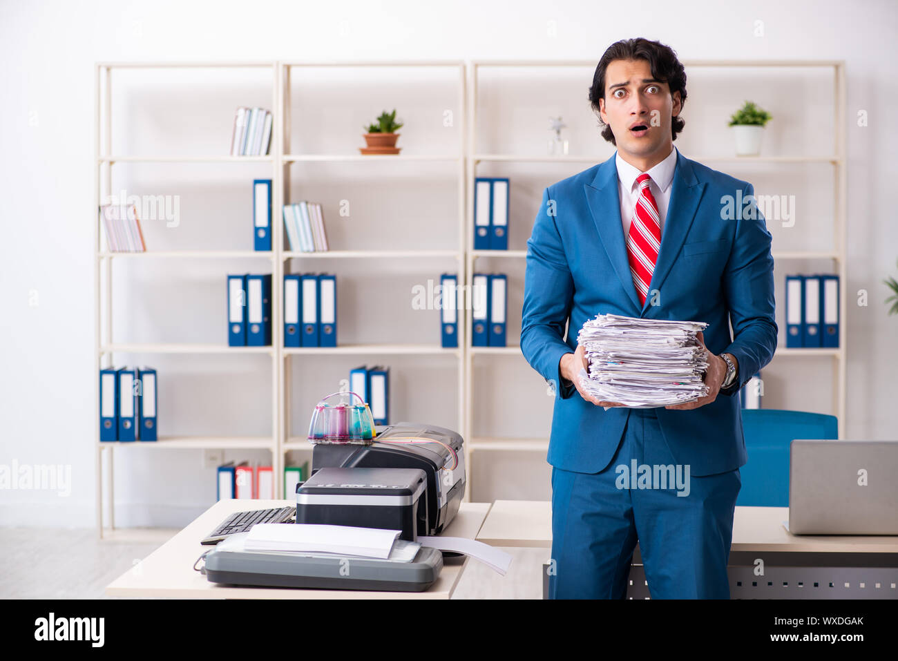 Young employee making copies at copying machine Stock Photo