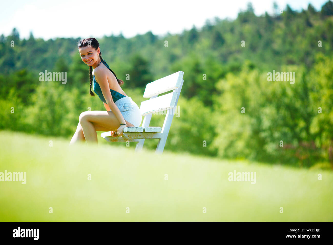 Young woman sitting on the bench in park Stock Photo - Alamy