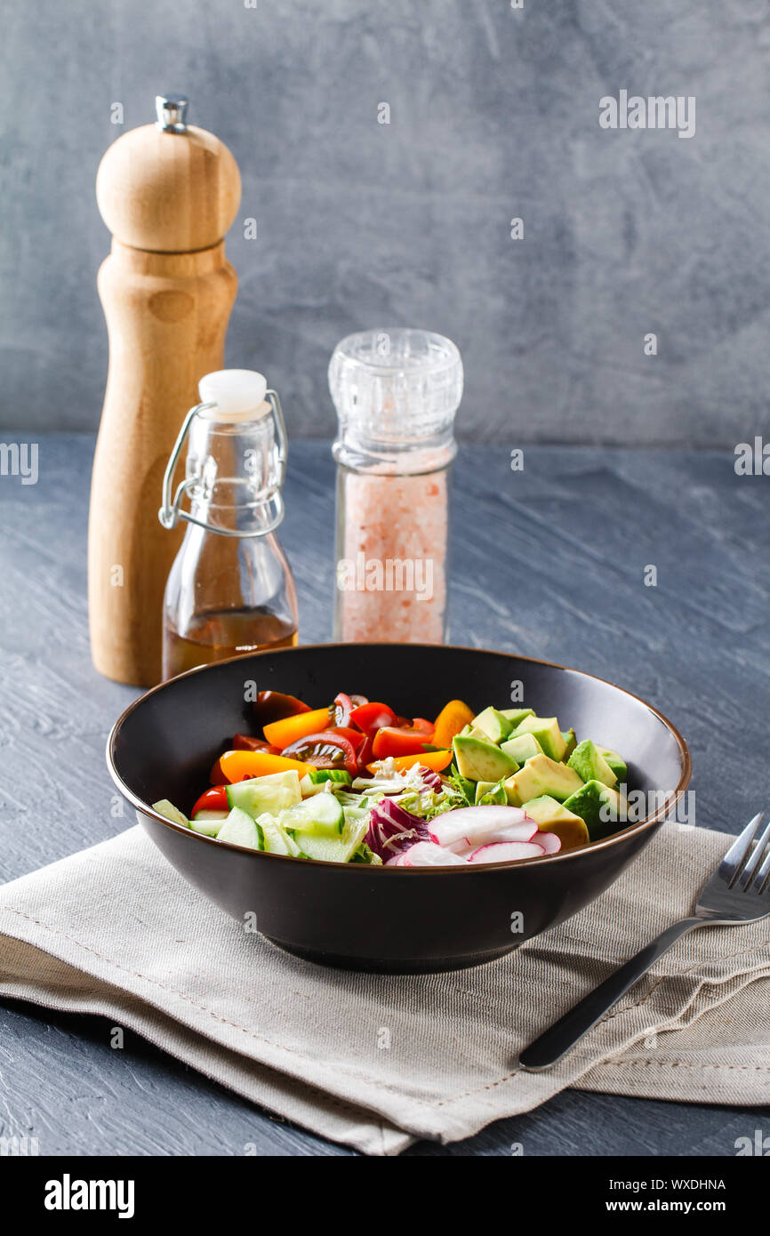 Vegan buddha bowl. Healthy vegetarian salad with cherry tomatoes, cucumber, radish,, avocado and lettuce. Stock Photo