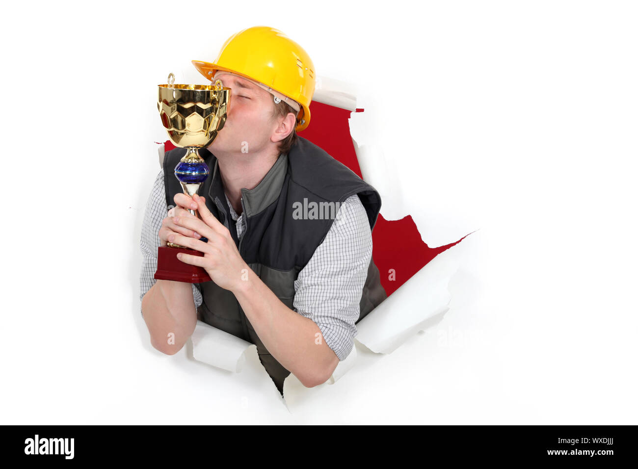 Construction worker kissing a trophy Stock Photo