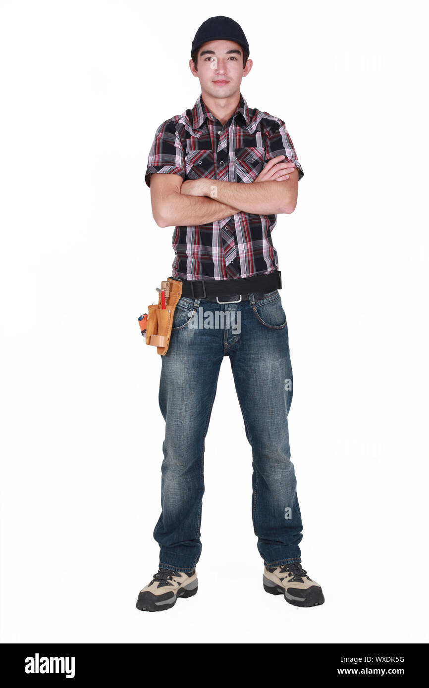 Young builder stood with arms folded Stock Photo