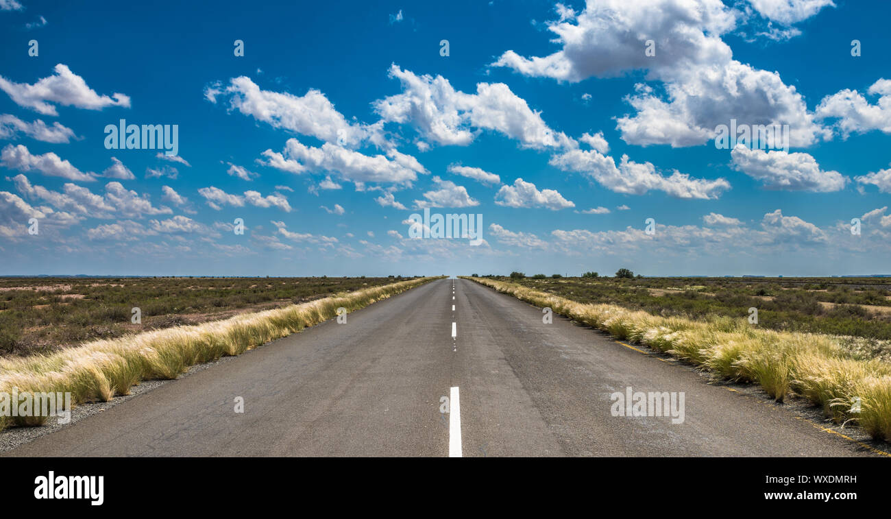vibrant image of desert road and blue cloudy sky Stock Photo