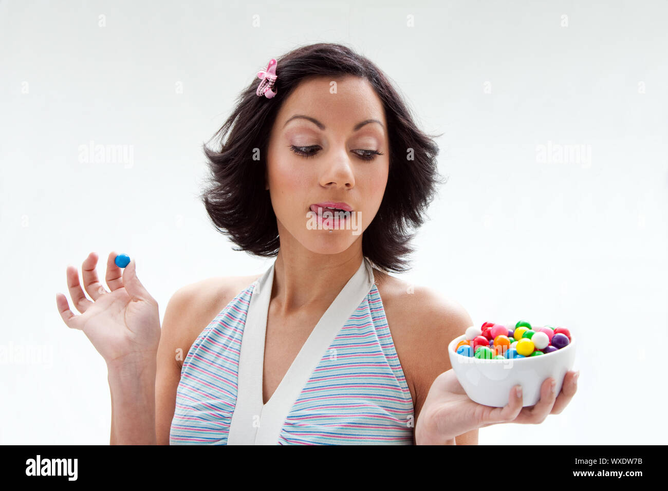 Happy beautiful candy girl with a bowl of colorful bubblegum candy