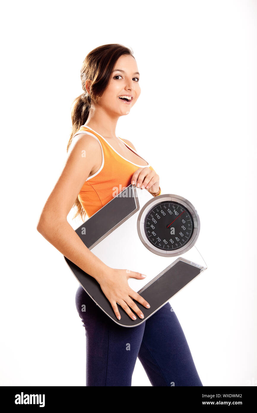 Portrait of a beautiful athletic girl holding a scale, isolated on ...
