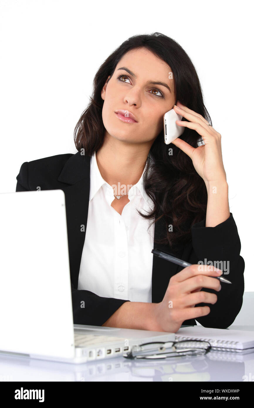 Assistant having phone call, studio shot Stock Photo
