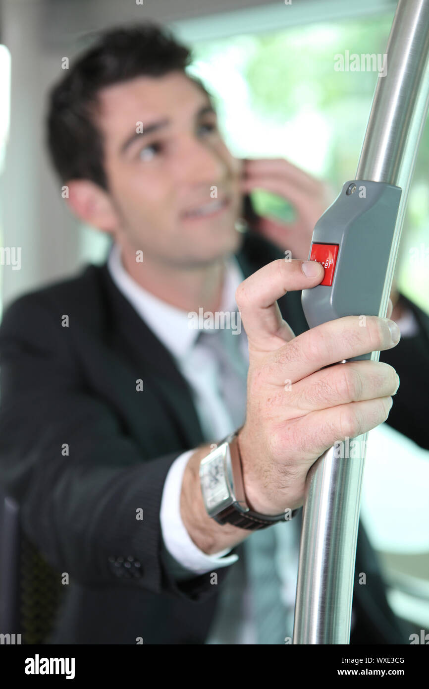 Businessman pressing button on bus Stock Photo - Alamy
