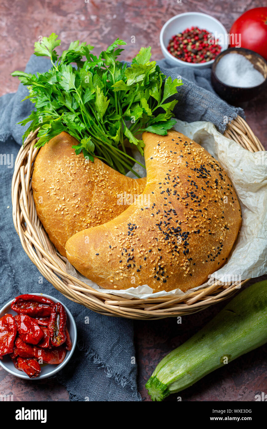 Pizza calzone with zucchini, dried tomatoes and cheese. Stock Photo