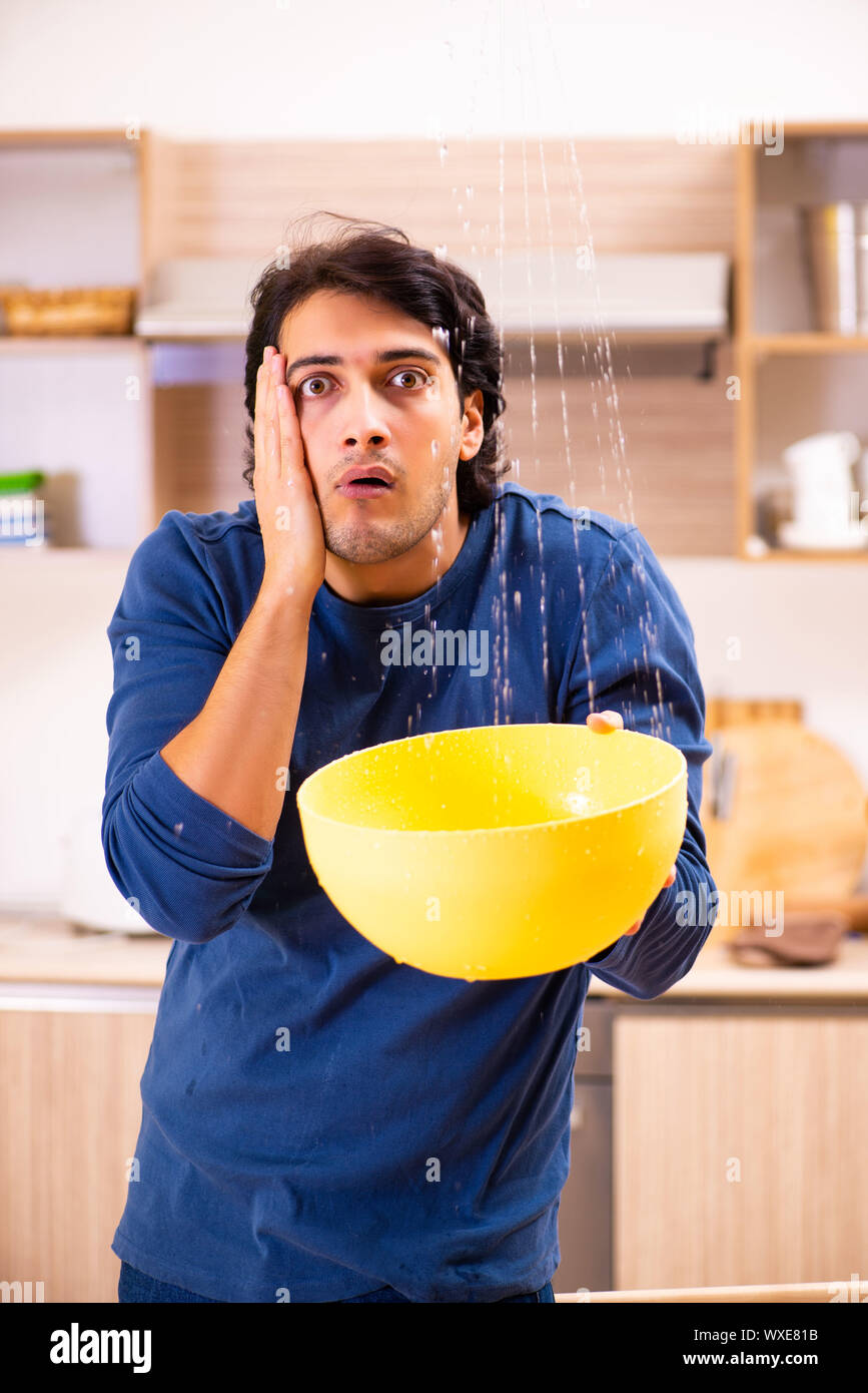 Young man in water leakage from the neighbors concept Stock Photo