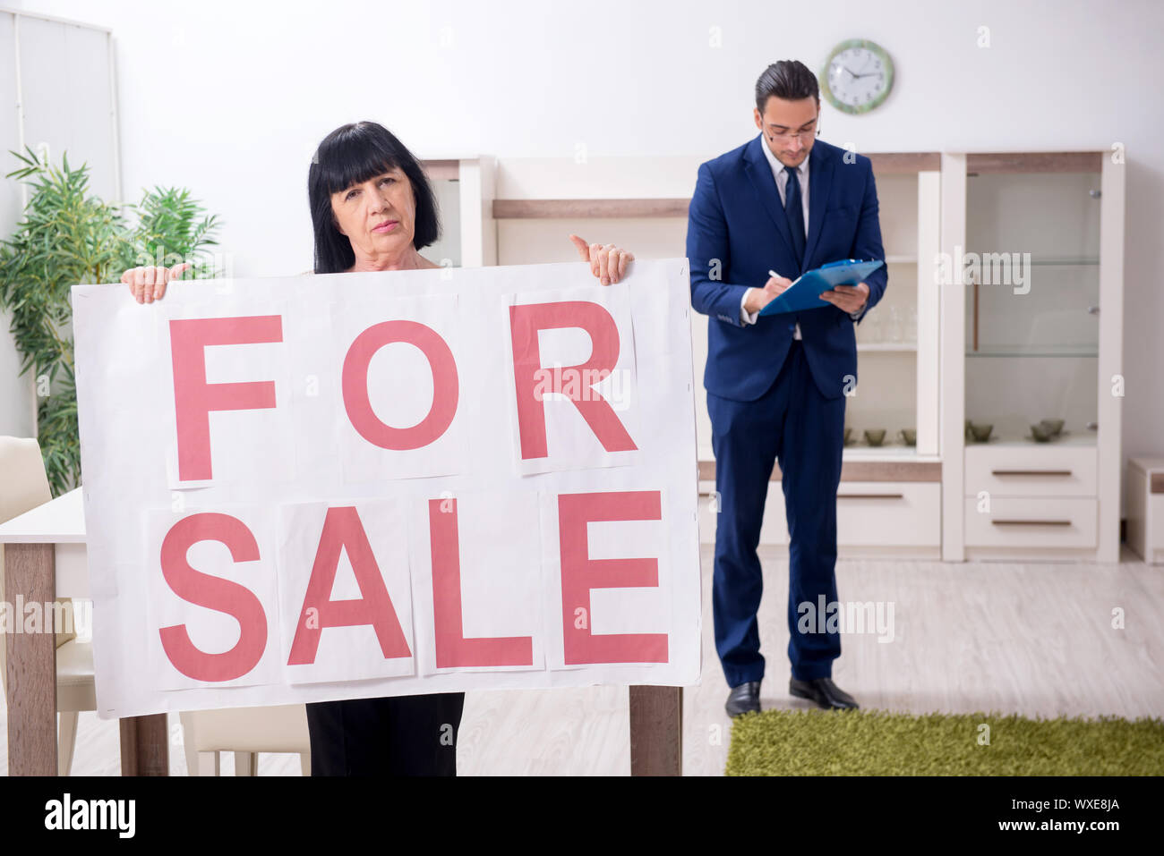 Male real estate agent and female client in the apartment Stock Photo - Alamy