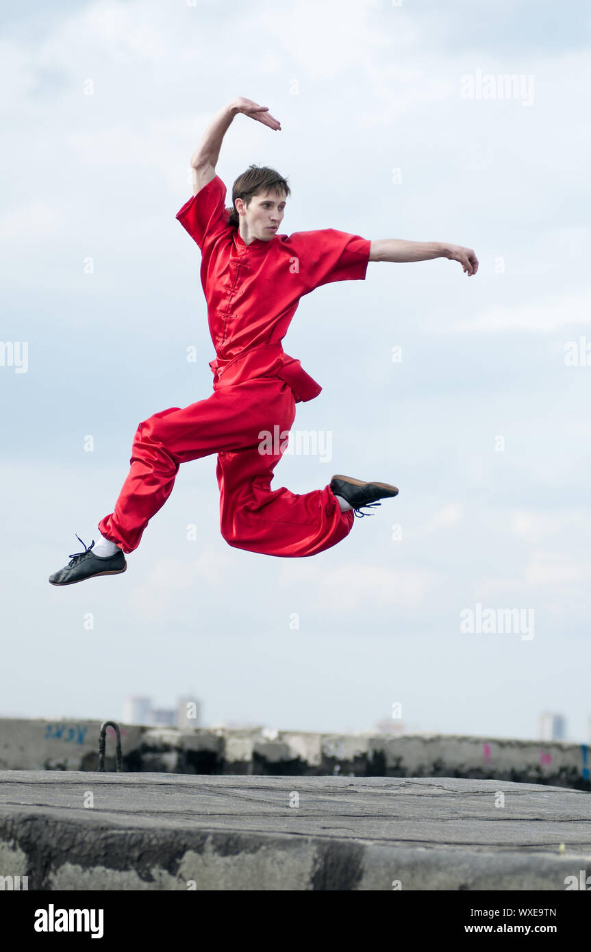 Shaolin warriors wushoo man in red practice martial art outdoor. Kung
