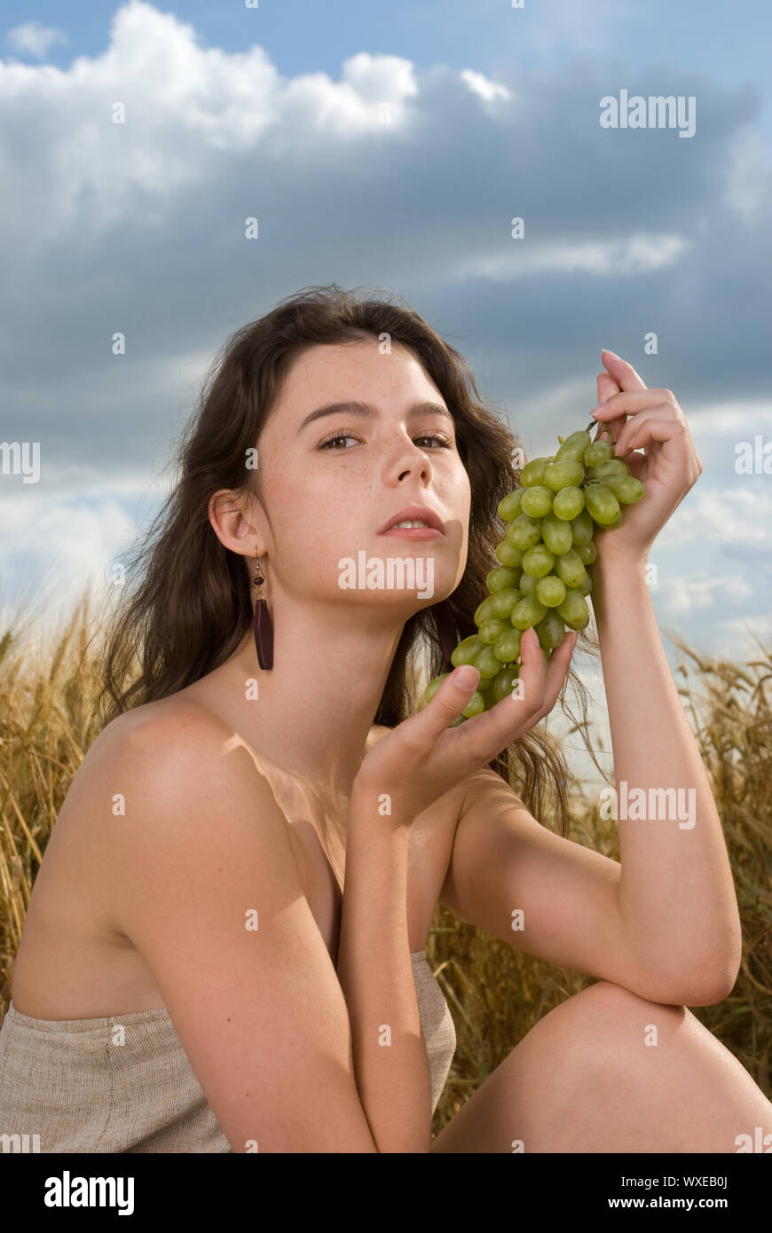 Beautiful slavonic girl on picnic in wheat field with grapes Stock ...