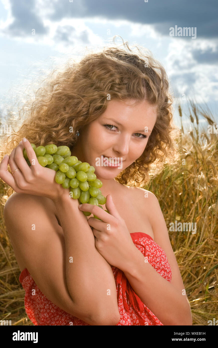 Beautiful slavonic girl on picnic in wheat field with grapes Stock ...