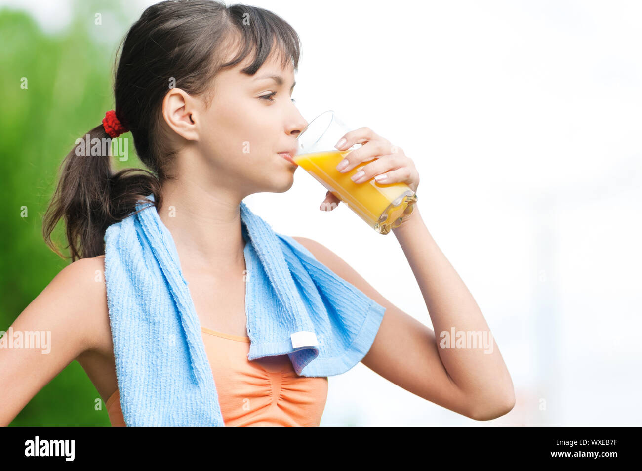Teenage girl drinking orange juice after fitness exercise Stock Photo