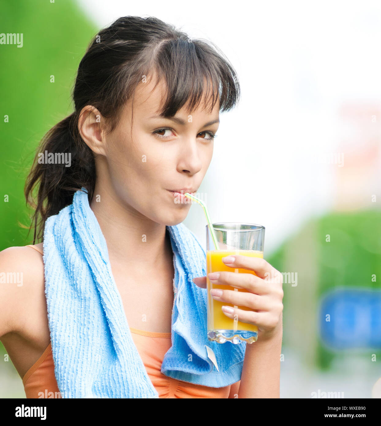 Teenage girl drinking orange juice after fitness exercise Stock Photo