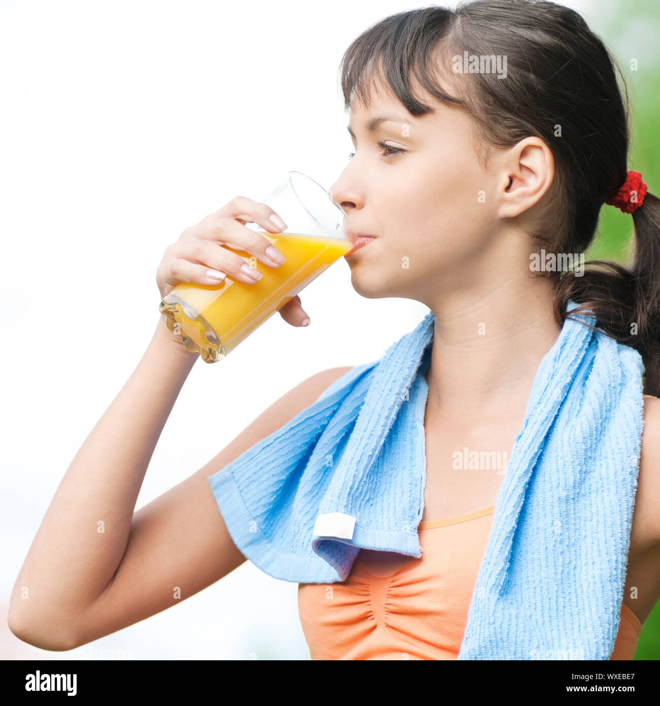 Teenage girl drinking orange juice after fitness exercise Stock Photo