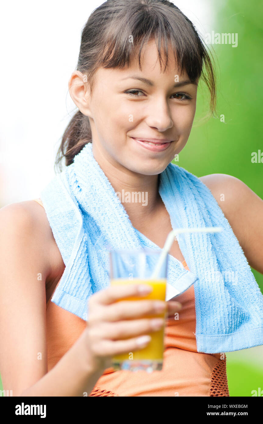 Teenage girl drinking orange juice after fitness exercise Stock Photo