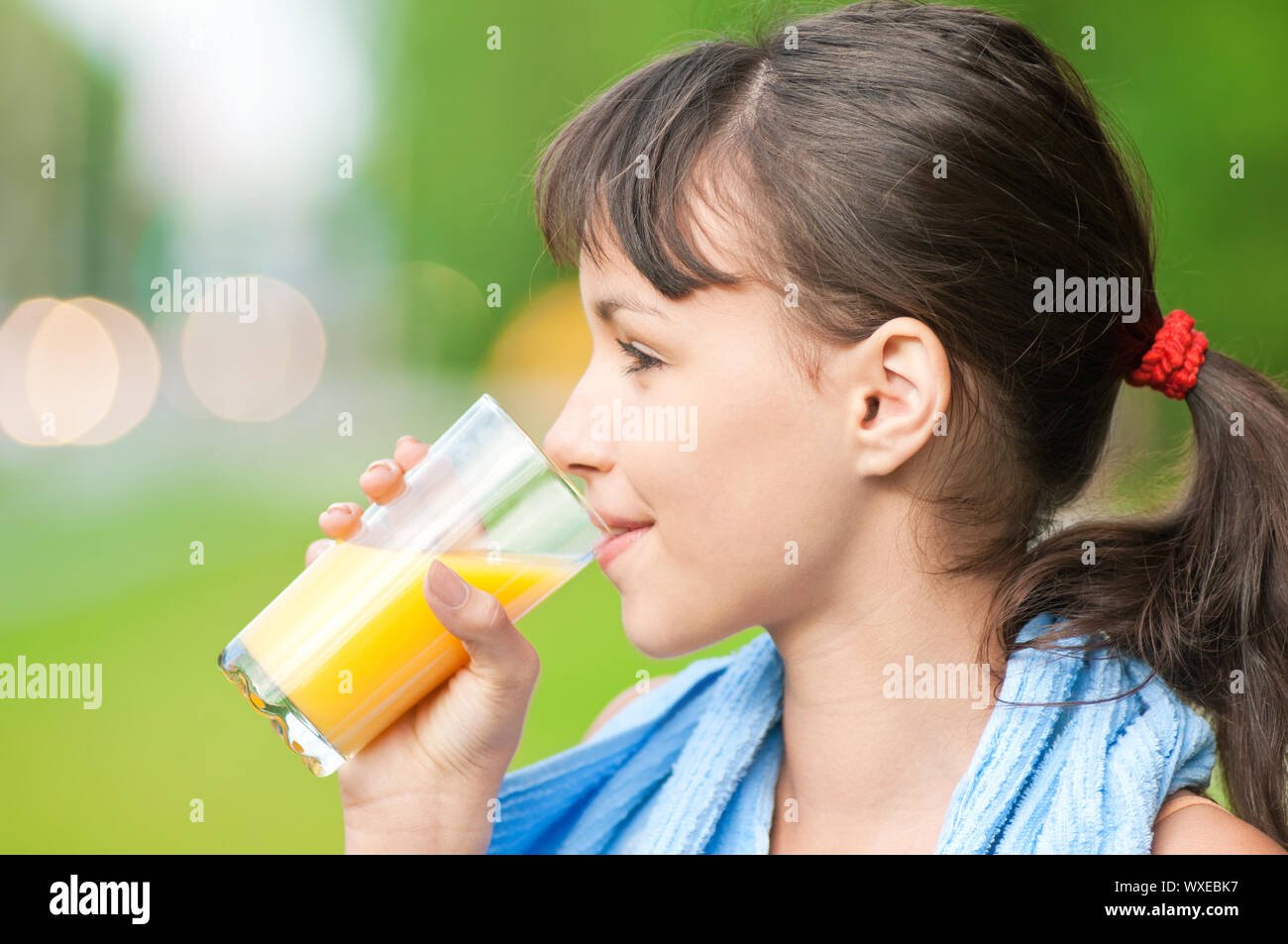 Teenage girl drinking orange juice after fitness exercise Stock Photo