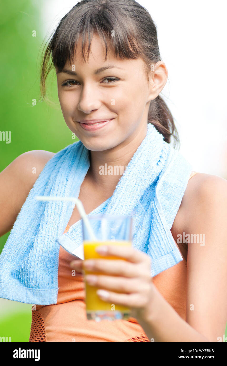 Teenage girl drinking orange juice after fitness exercise Stock Photo