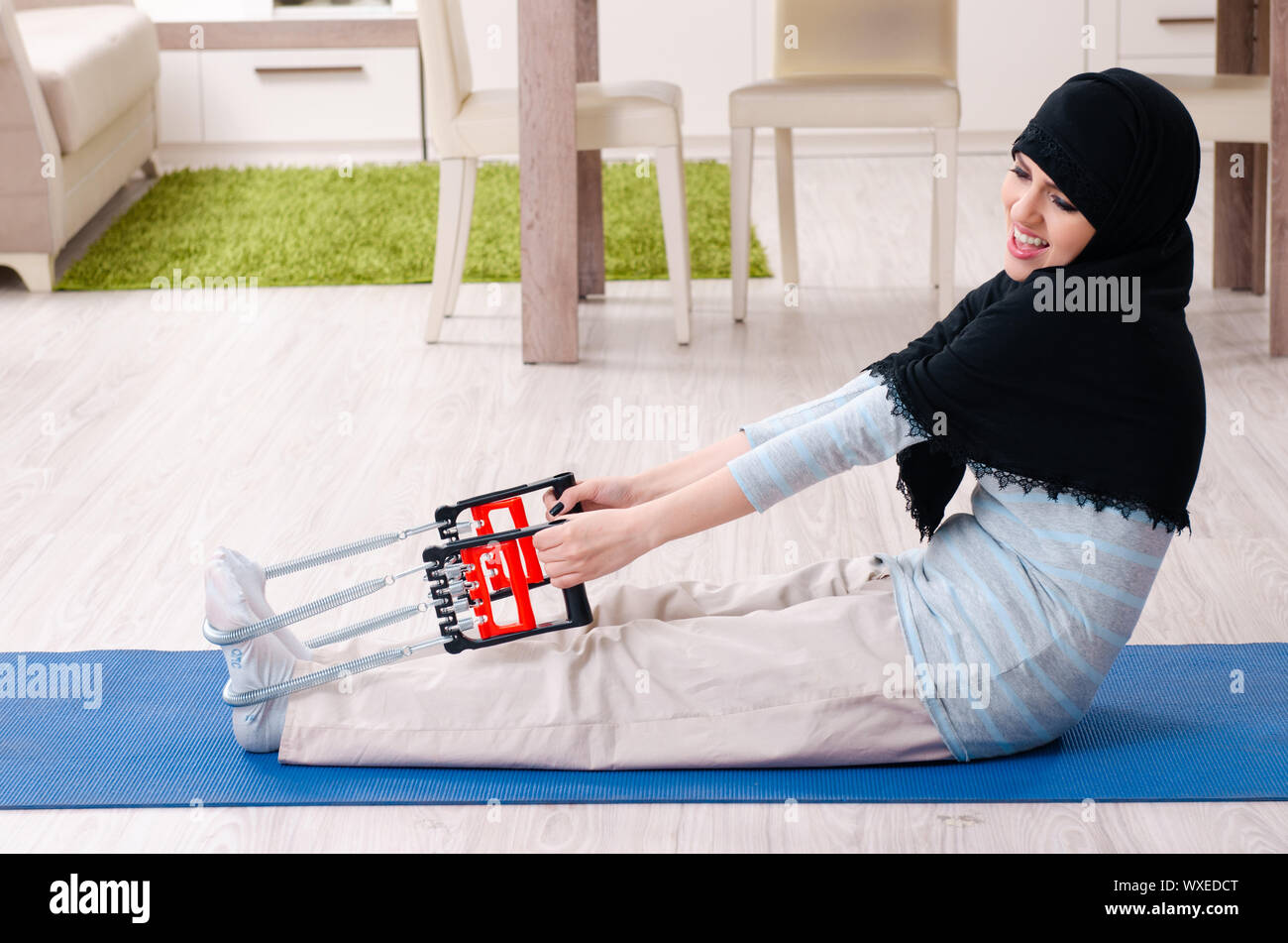 Young woman in hijab doing exercises at home Stock Photo - Alamy
