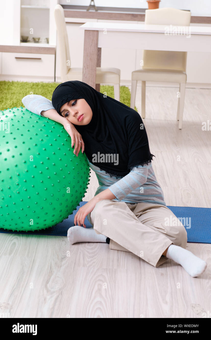 Young woman in hijab doing exercises at home Stock Photo - Alamy