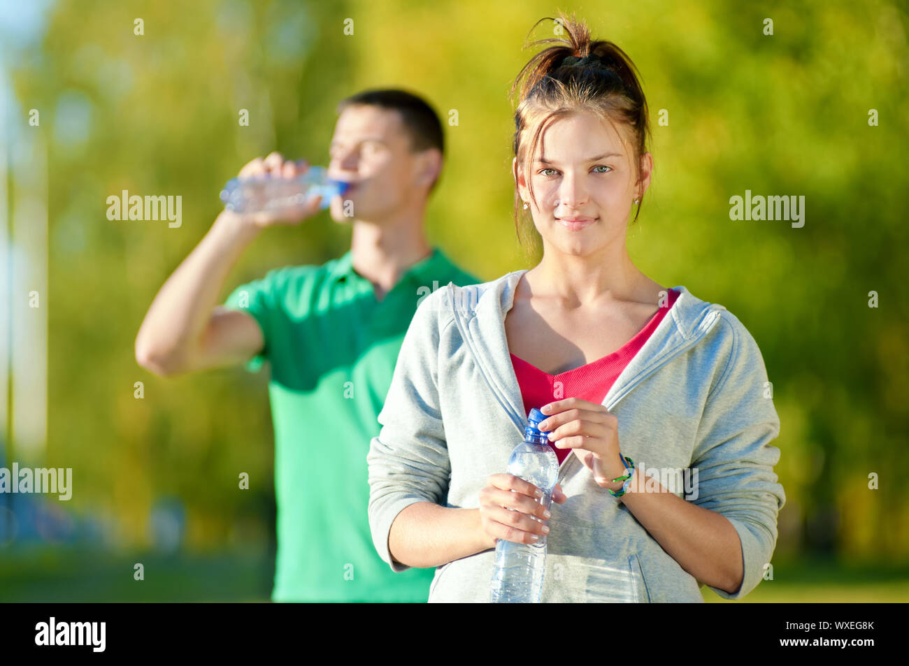 Свежий воздух и вода. Мужчина и женщина пьют воду. Пить на свежем воздухе. Здоровый образ жизни вода. Человек пьет воду.