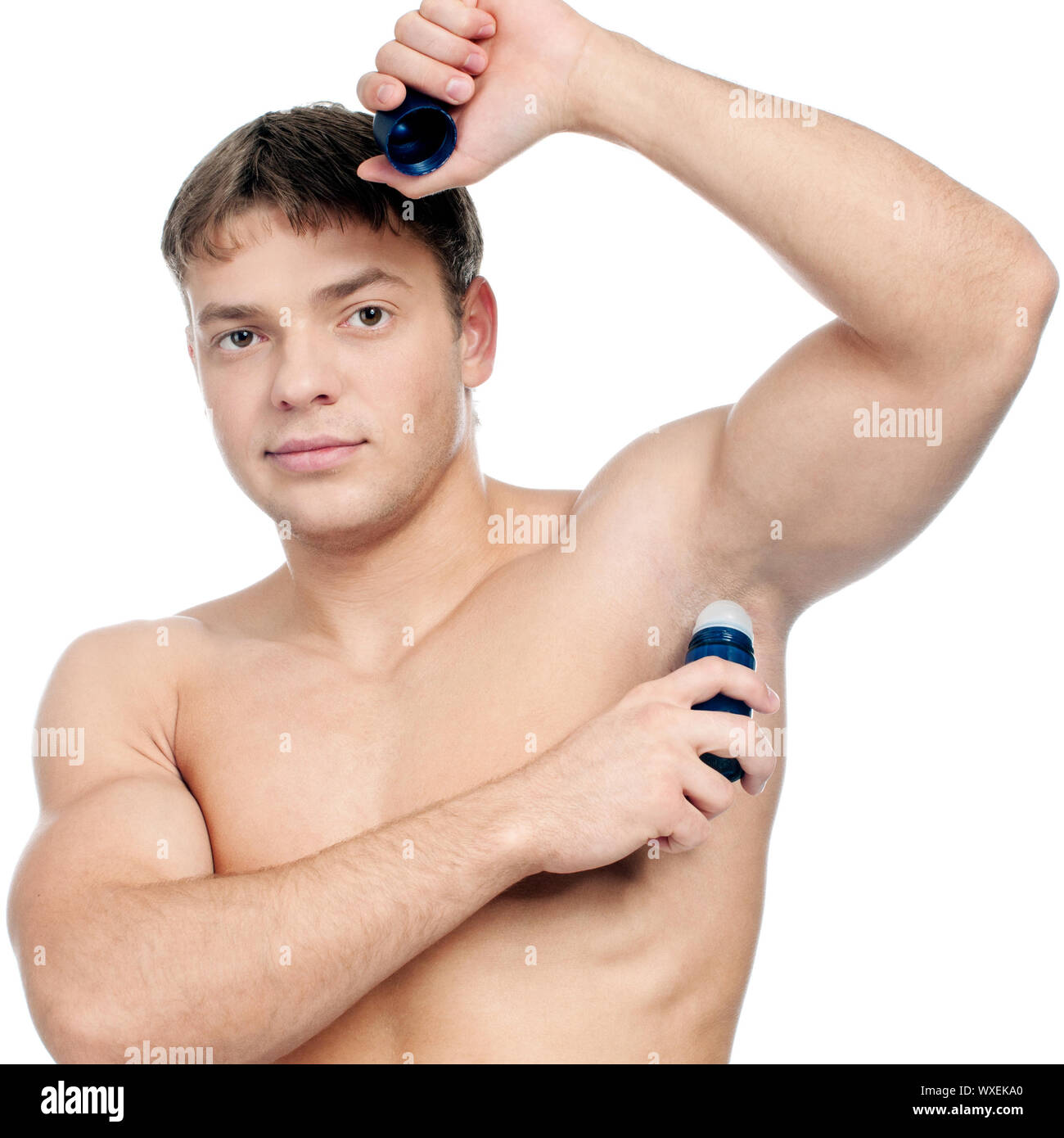 Muscular man's using an antiperspirant. Isolated on white Stock Photo