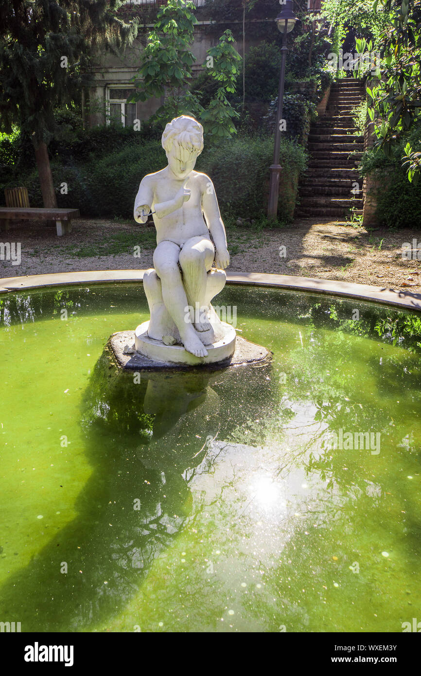 white greek statue in fountain of botanical garden Stock Photo