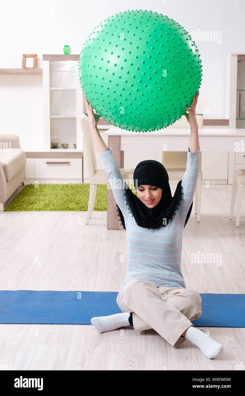 Young woman in hijab doing exercises at home Stock Photo - Alamy