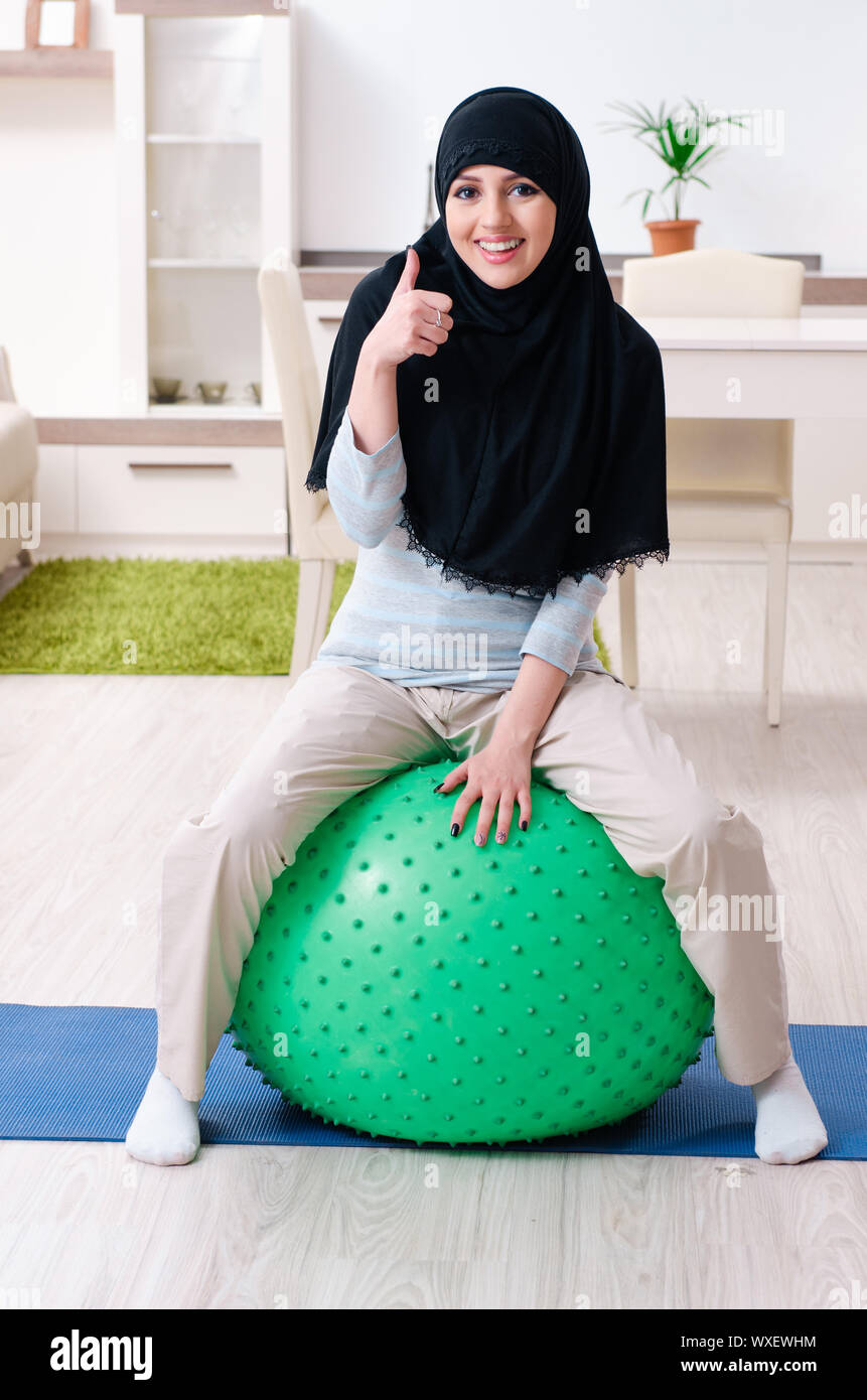 Young woman in hijab doing exercises at home Stock Photo - Alamy