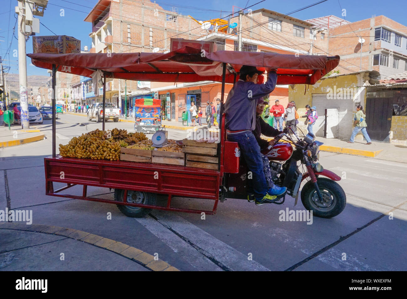 farmer and merchant driving their motorcycle and stall to sell their corn at the market in Huaraz Stock Photo