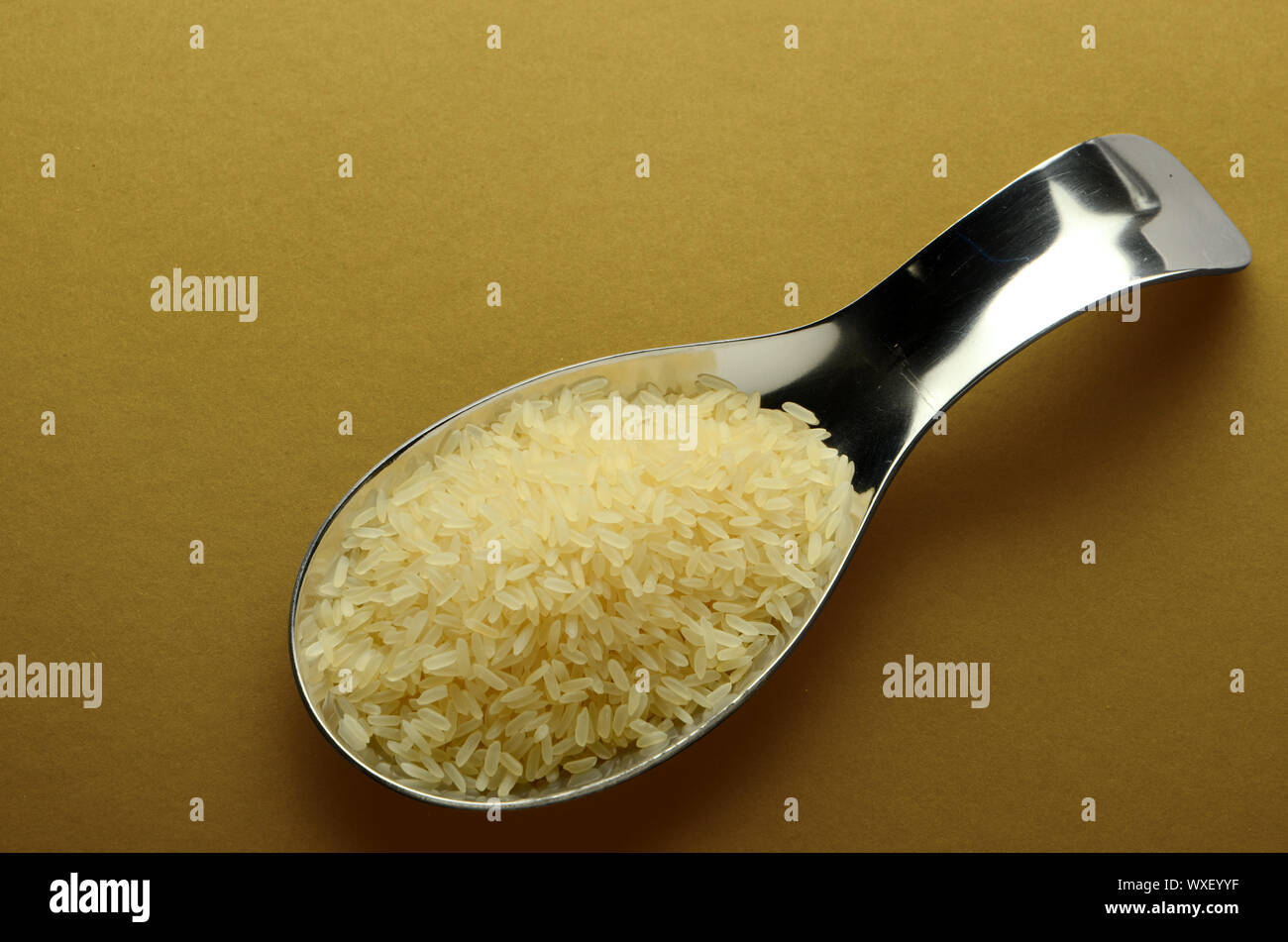Raw polished rice in spoons on a light background top view Stock Photo ...