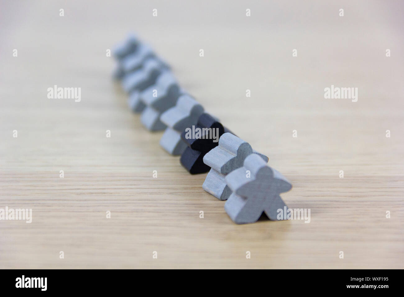 Gray gaming pieces and a black meeple, diversity concept Stock Photo