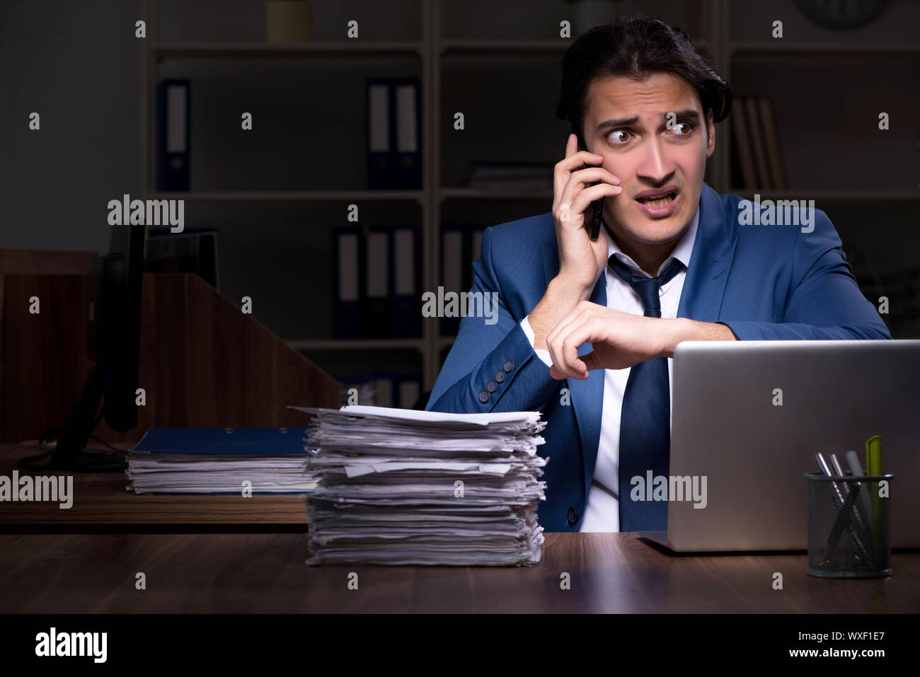 Young male employee working night in the office Stock Photo