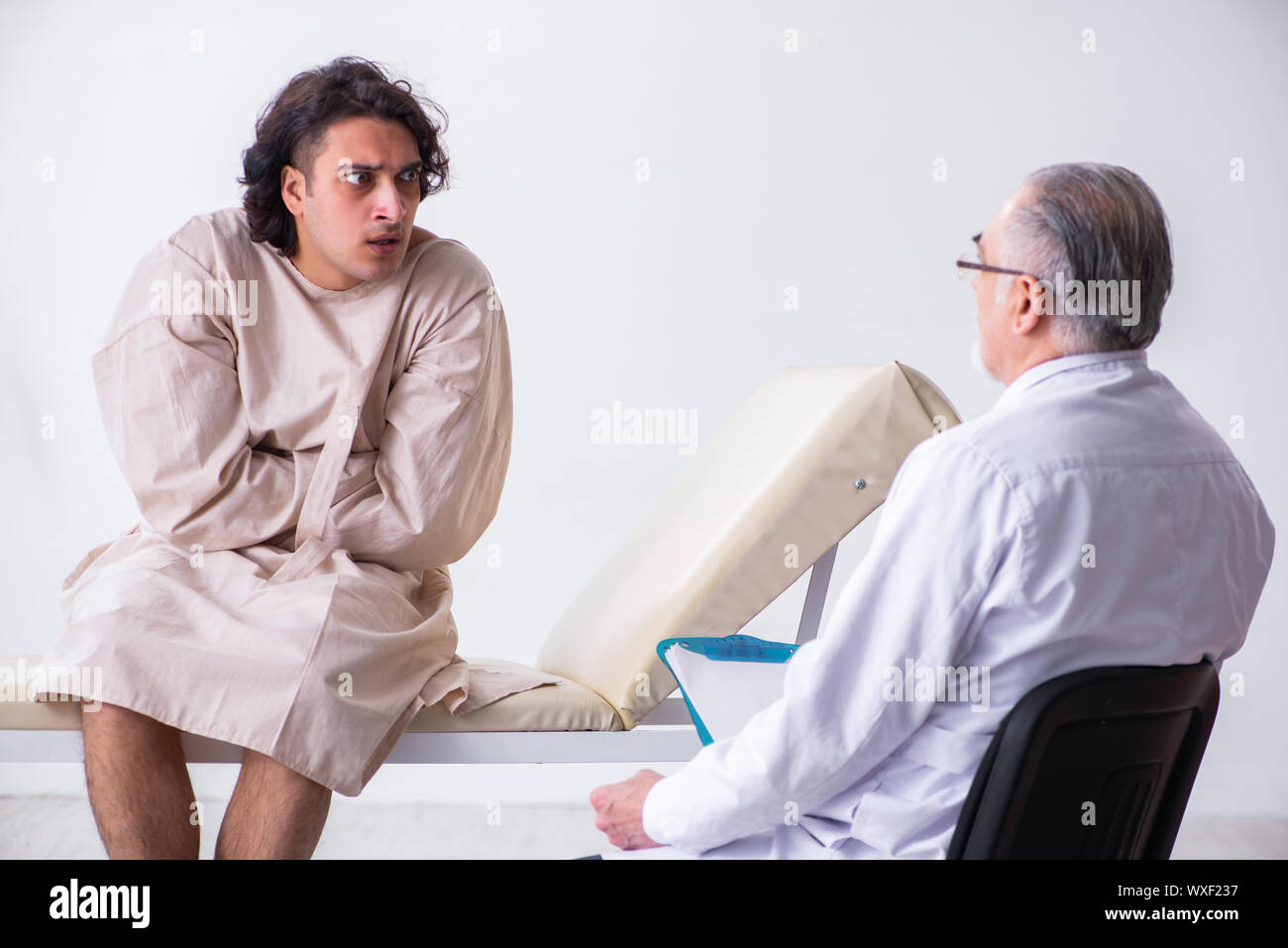 Aged male doctor psychiatrist examining young patient Stock Photo Alamy