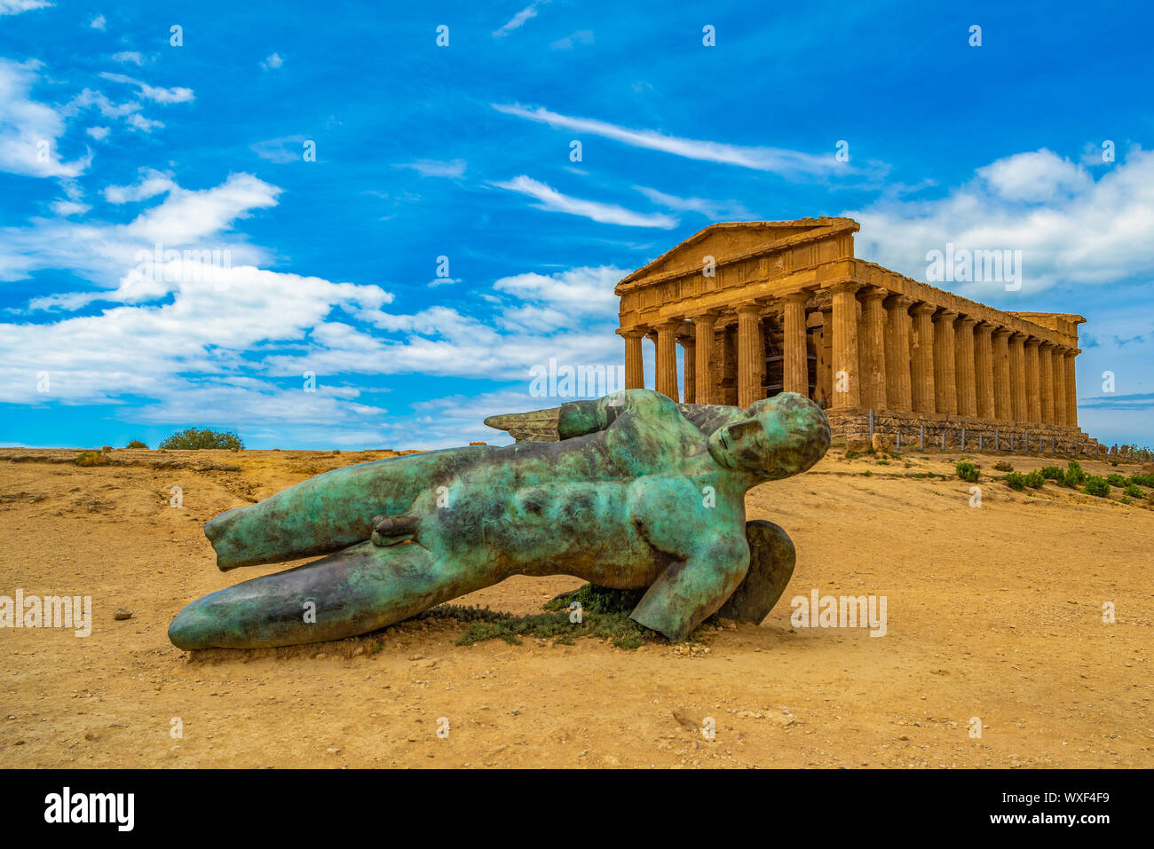 Temple of Concordia and the statue of Fallen Icarus, in the Valley of the Temples, Agrigento, Sicily, Italy Stock Photo
