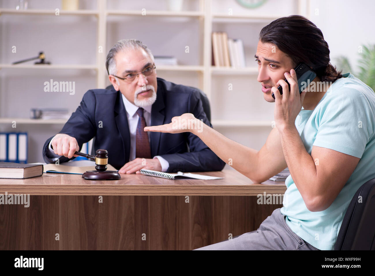 Young man visiting experienced male lawyer Stock Photo