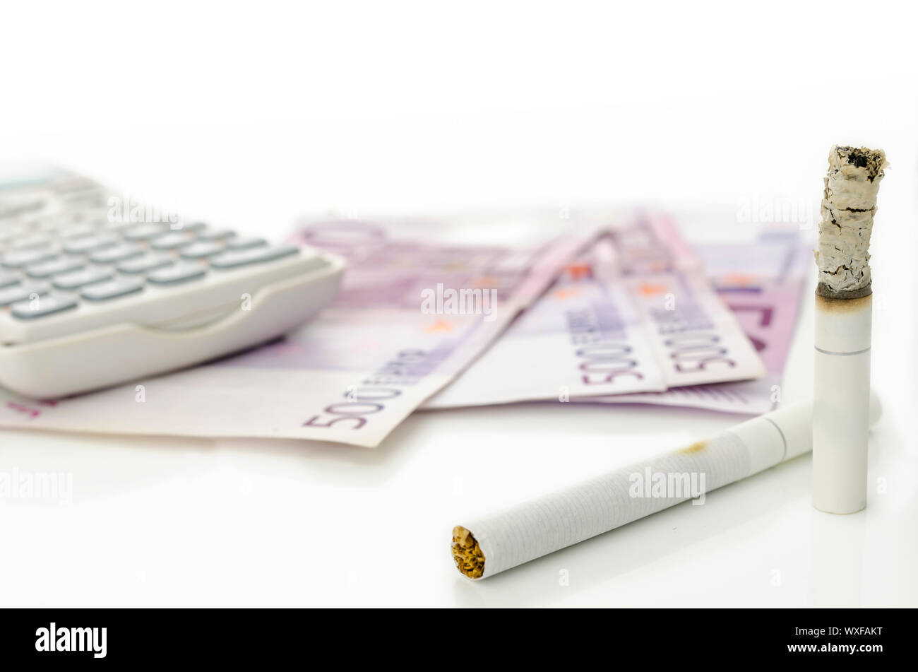 Half burned cigarette with calculator and Euro money. Concept of big  financial burden smoking is Stock Photo