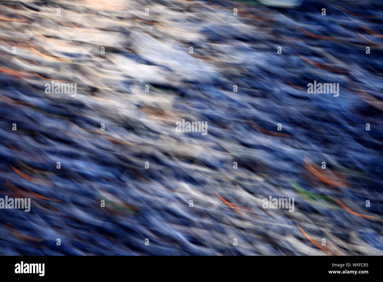 Blurred abstract image of countryside road surface with stones and autumn leaves taken in motion Stock Photo