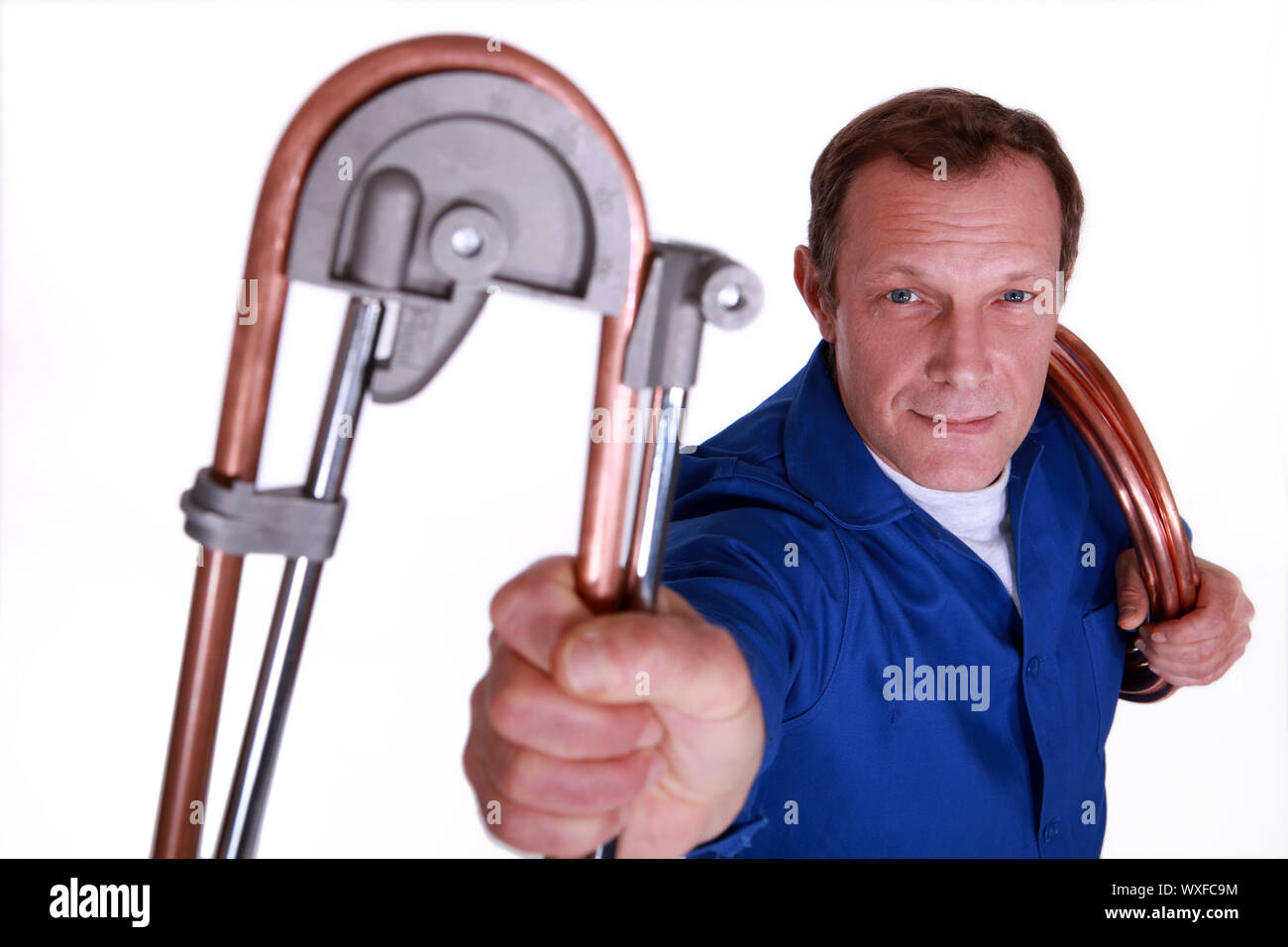 Plumber bending copper piping Stock Photo