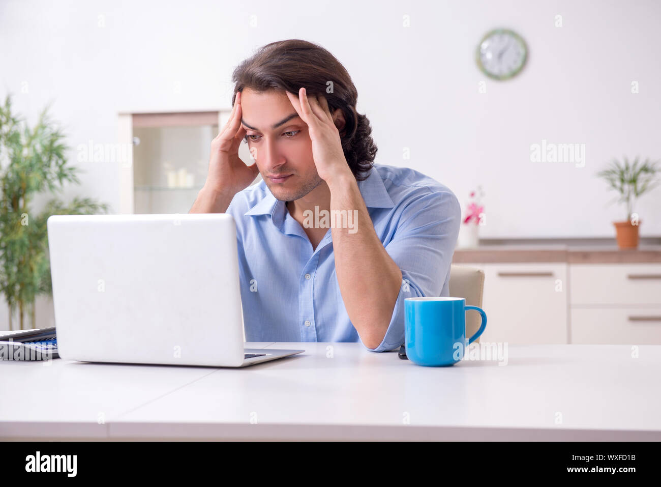 Young male employee working at home Stock Photo