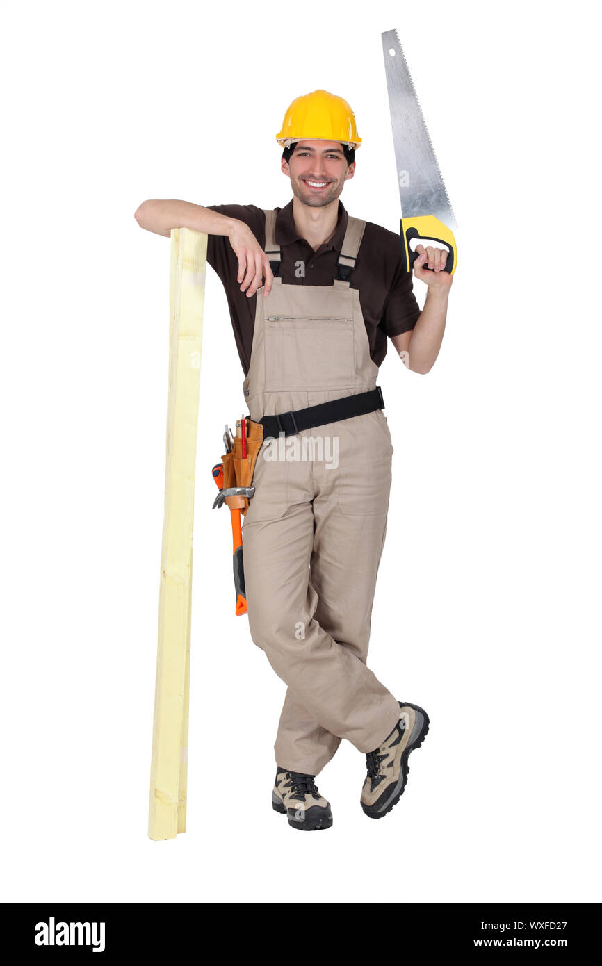 Tradesman holding a saw and a plank of wood Stock Photo