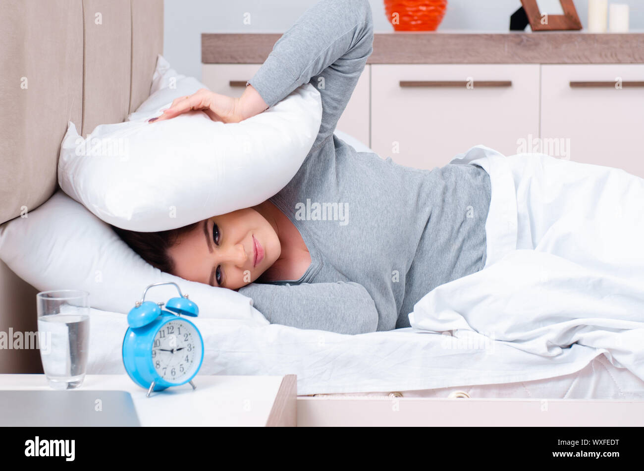 Young woman lying on the bed in time management concept Stock Photo Alamy