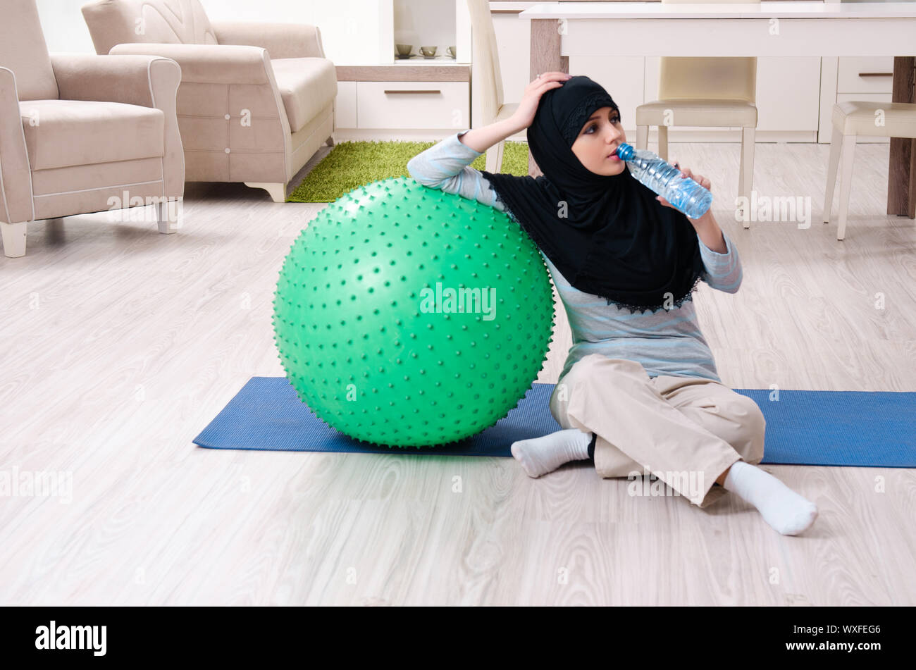Young woman in hijab doing exercises at home Stock Photo - Alamy