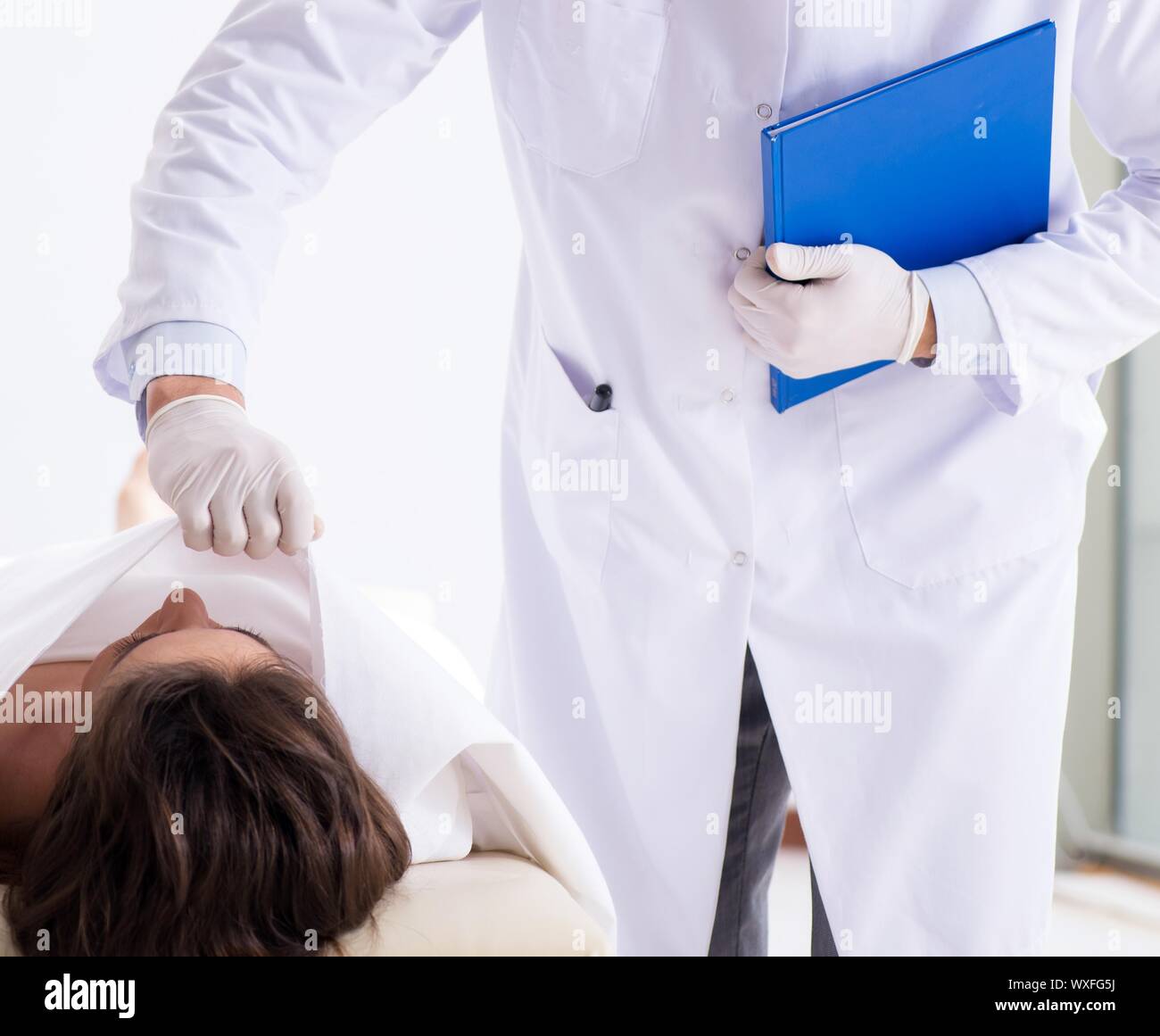 Police coroner examining dead body corpse in morgue Stock Photo