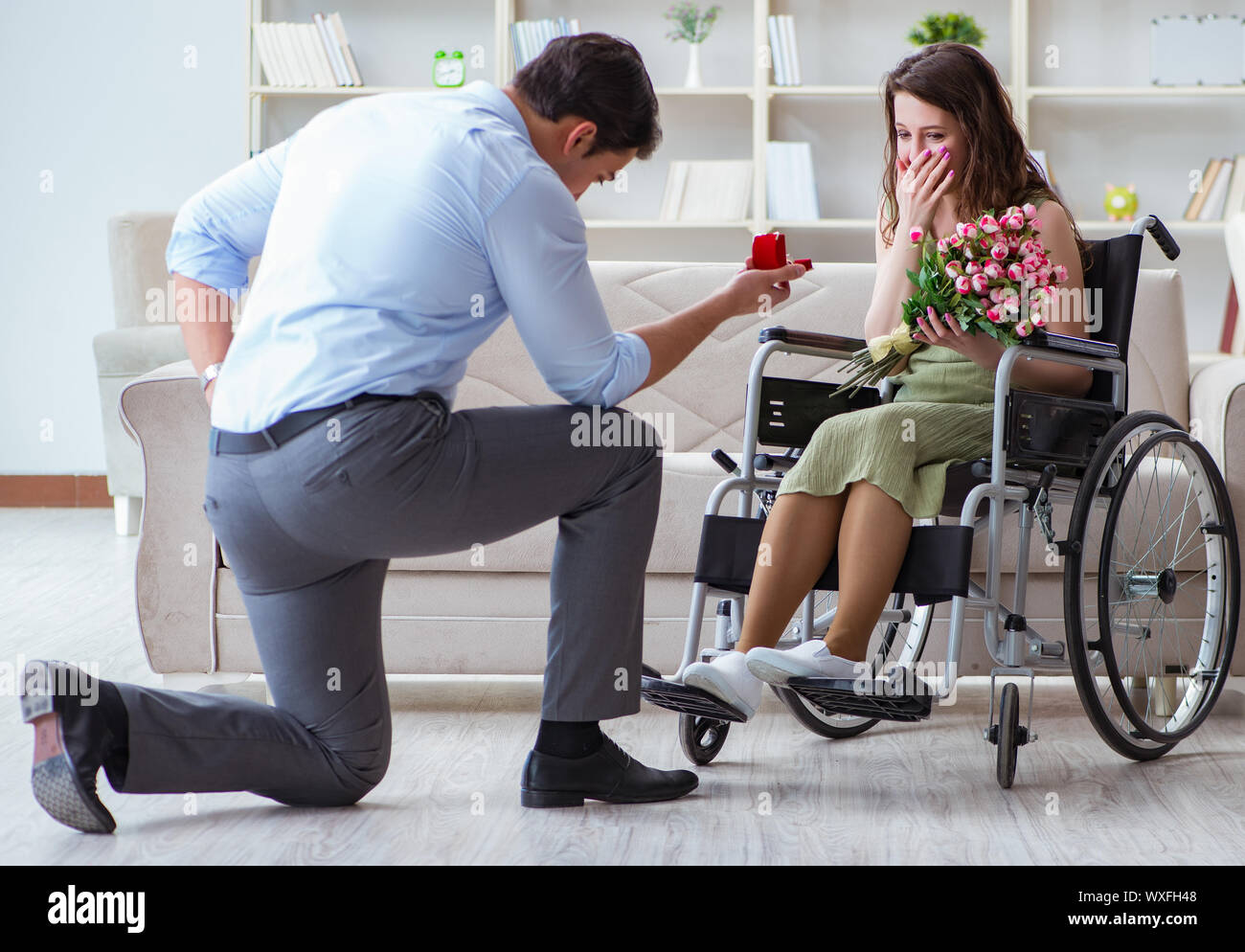 Man making marriage proposal to disabled woman on wheelchair Stock Photo