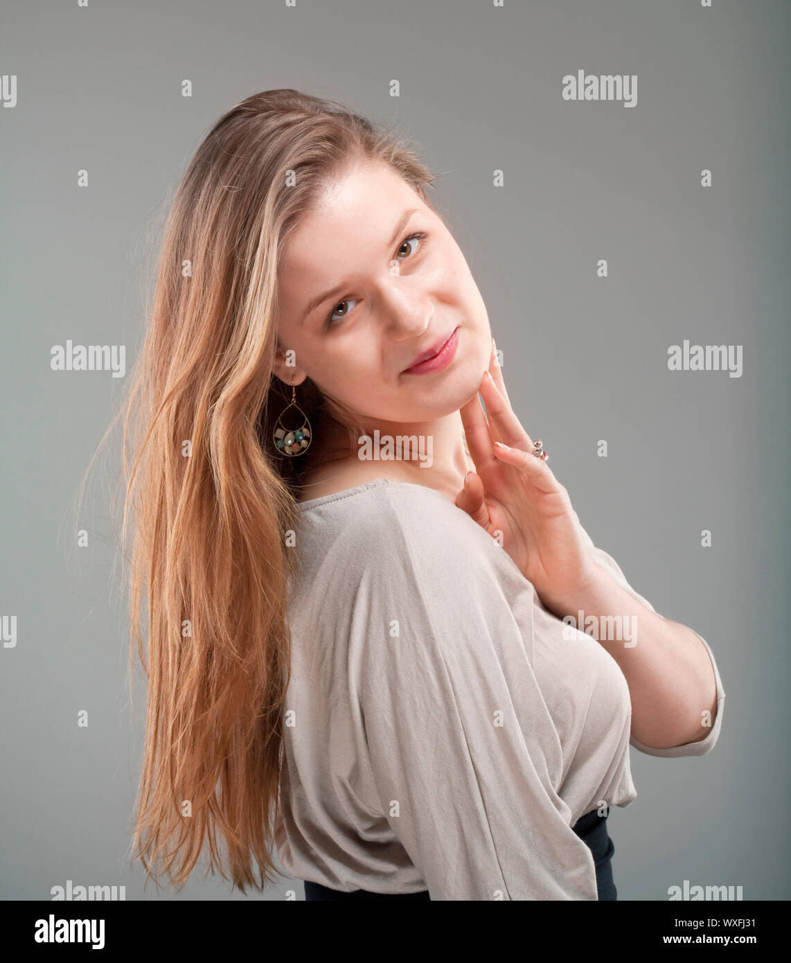 portrait of a young beautiful woman with brown hair - isolated on gray ...