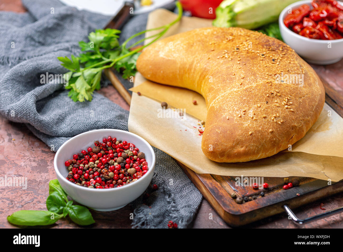 Homemade pizza calzone on a wooden board. Stock Photo