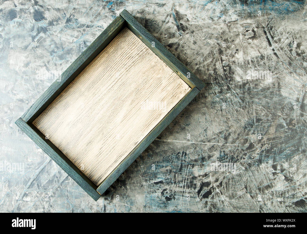 TEXTURE BOX ON BACKGROUND. A WOODEN BOX STANDS ON A DARK FACE BACKGROUND. Stock Photo