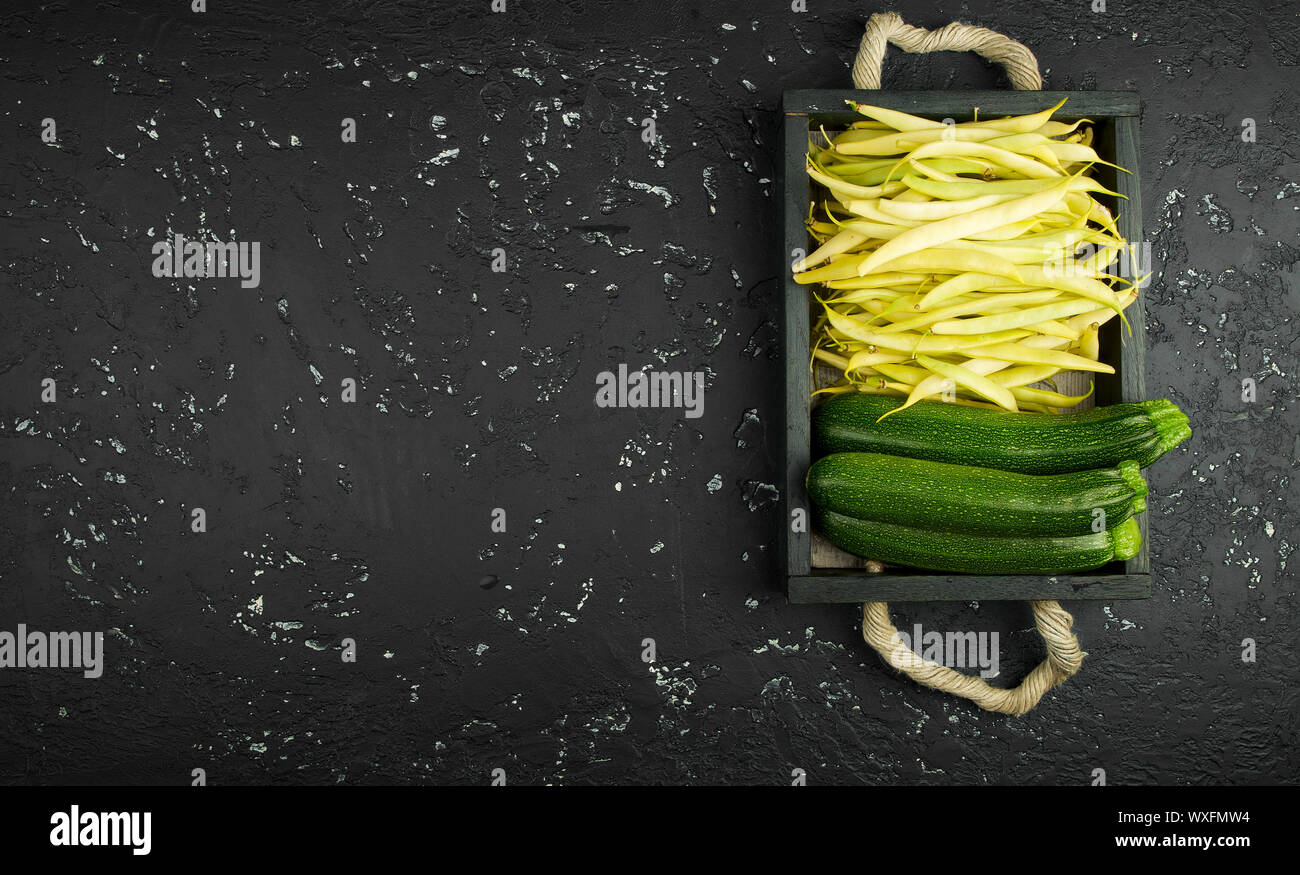 Fresh string beans in a box on a dark table. View from above. Copy space Stock Photo