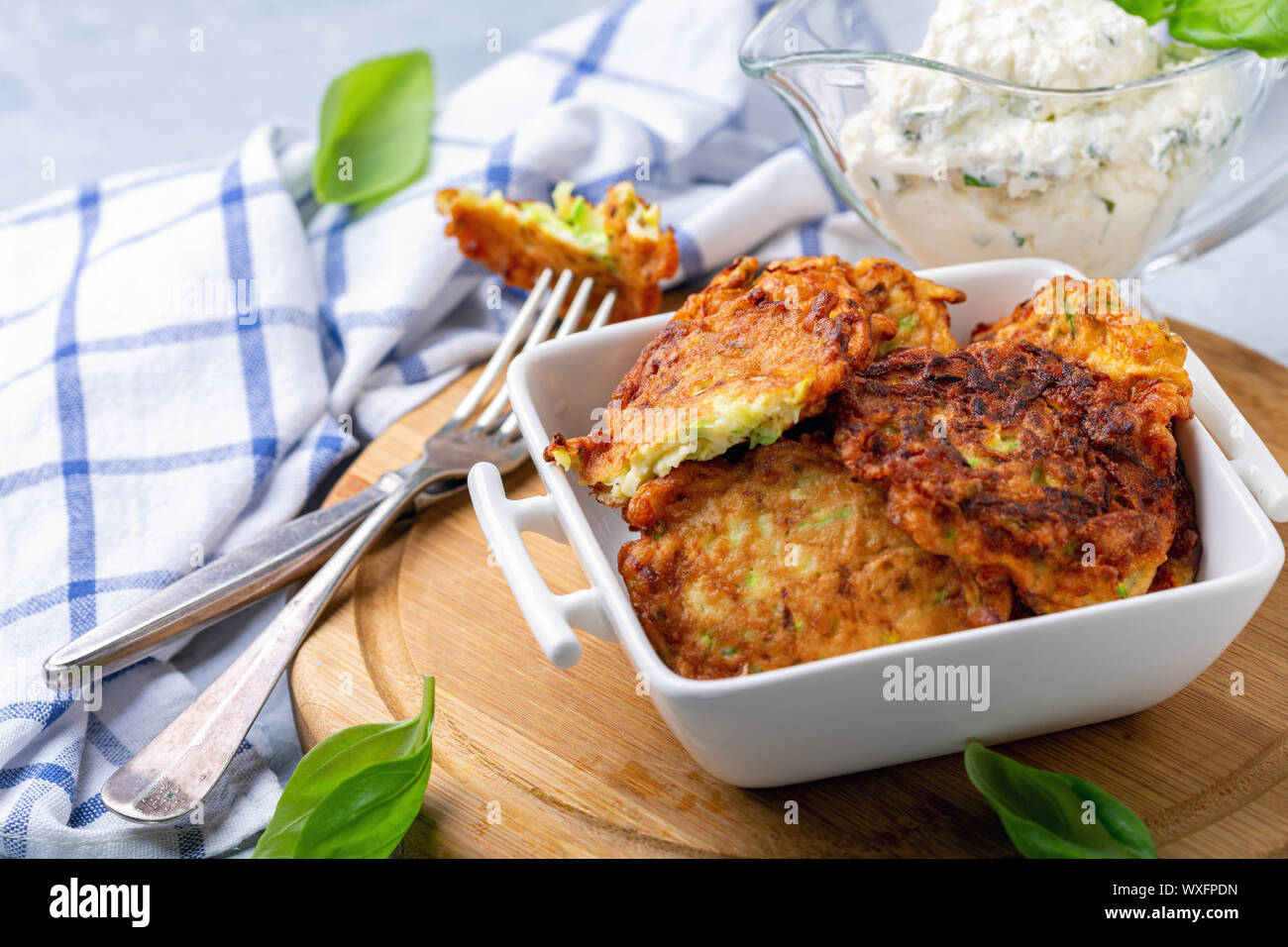 Zucchini fritters with sour cream sauce Stock Photo Alamy